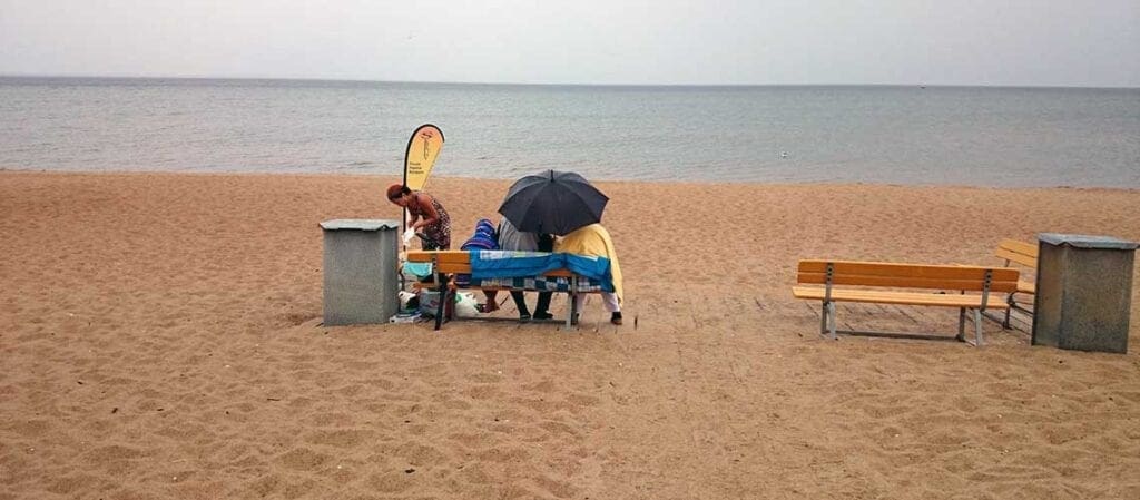 tre personer på en sandstrand