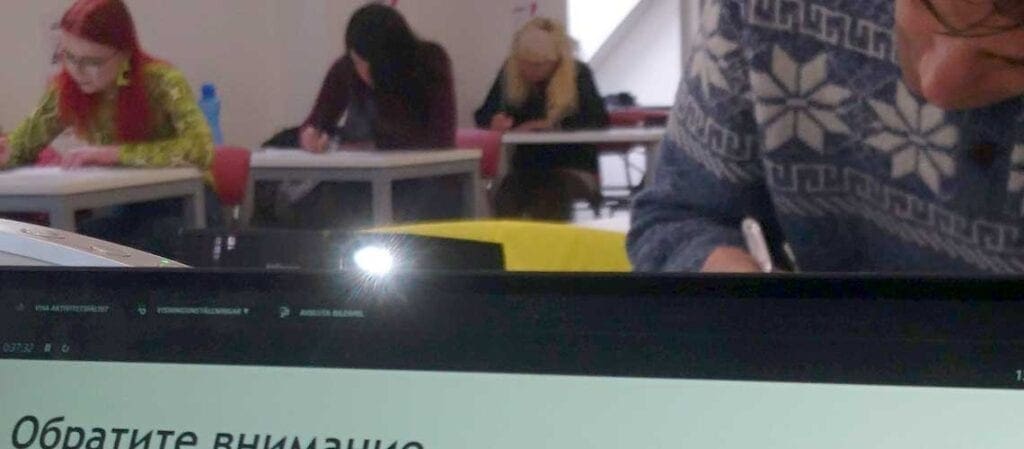 människor som sitter och skriver vid bord